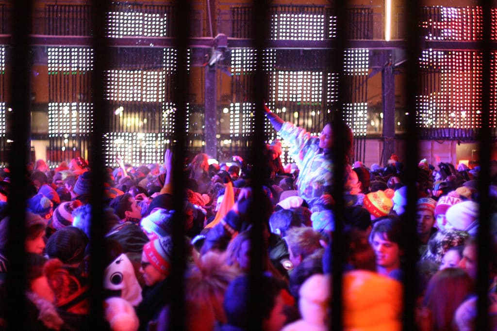 Security staff checking a festival-goer's small bag at the Igloofest gate in winter