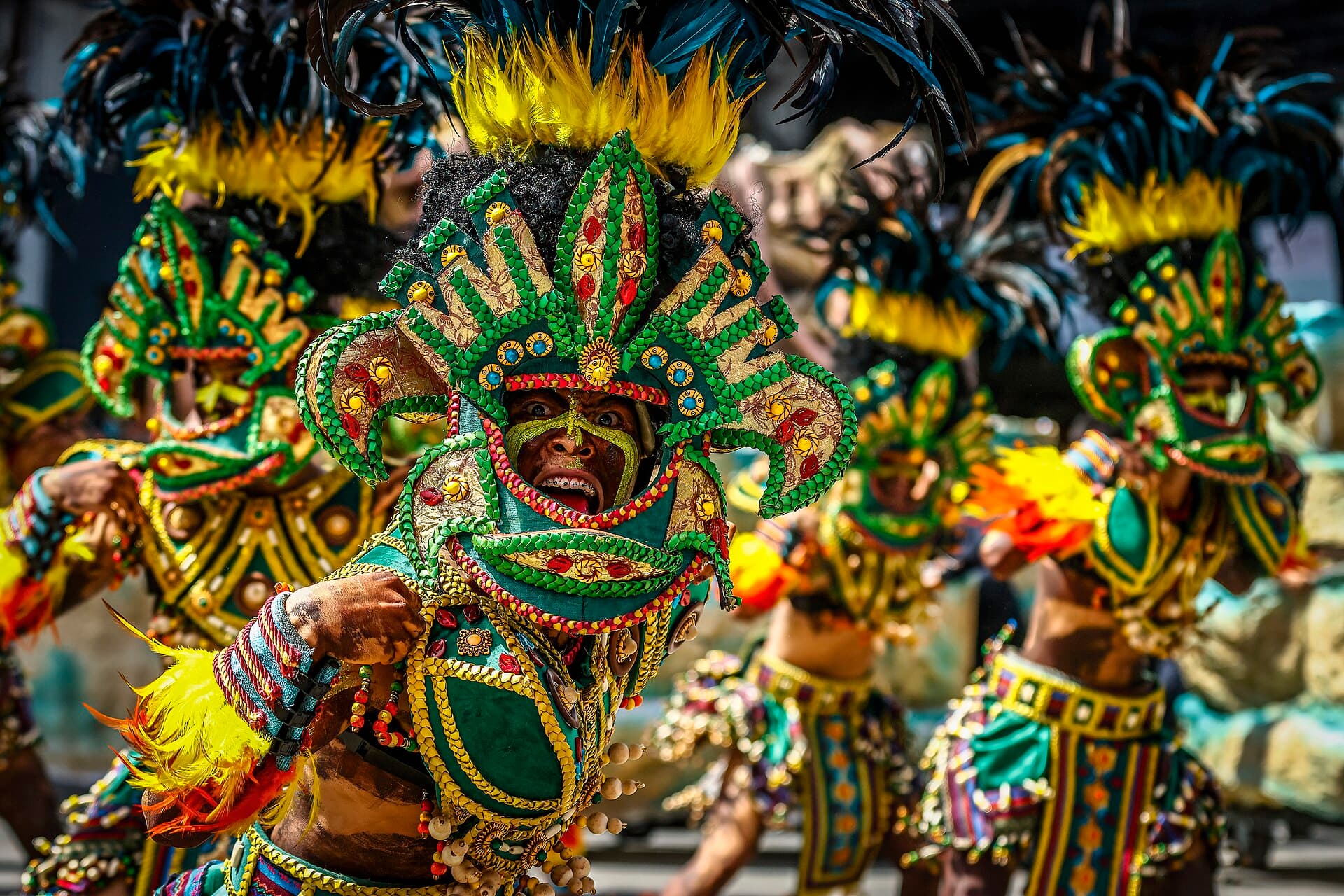 Crowd holding up phones to film a Dinagyang tribe formation on a downtown street in Iloilo City