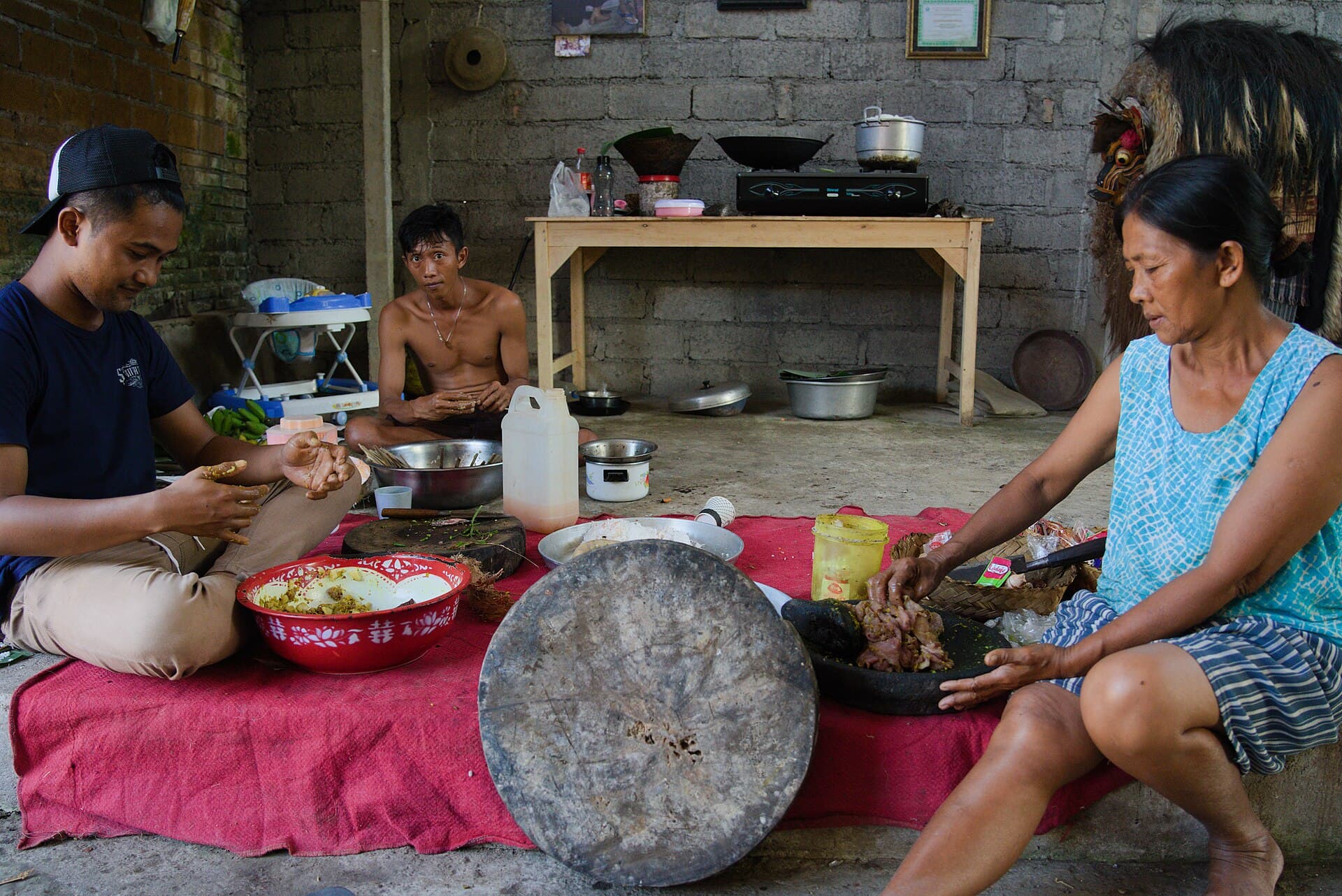 Mekotek ritual in Munggu village, Badung, with young men stacking long wooden poles into a pyramid