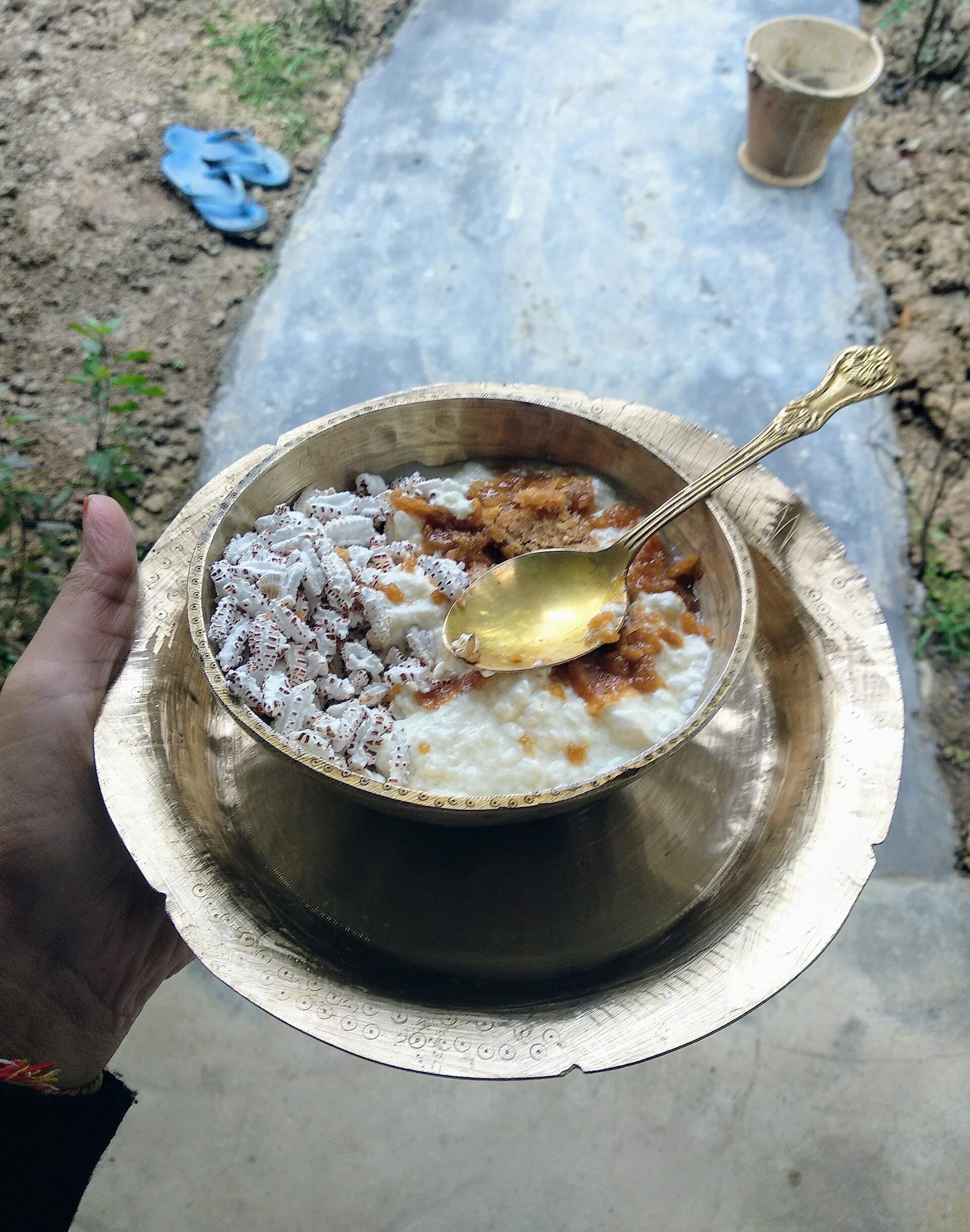 A plate of homemade til pitha, laru and tea served at a household during Bihu