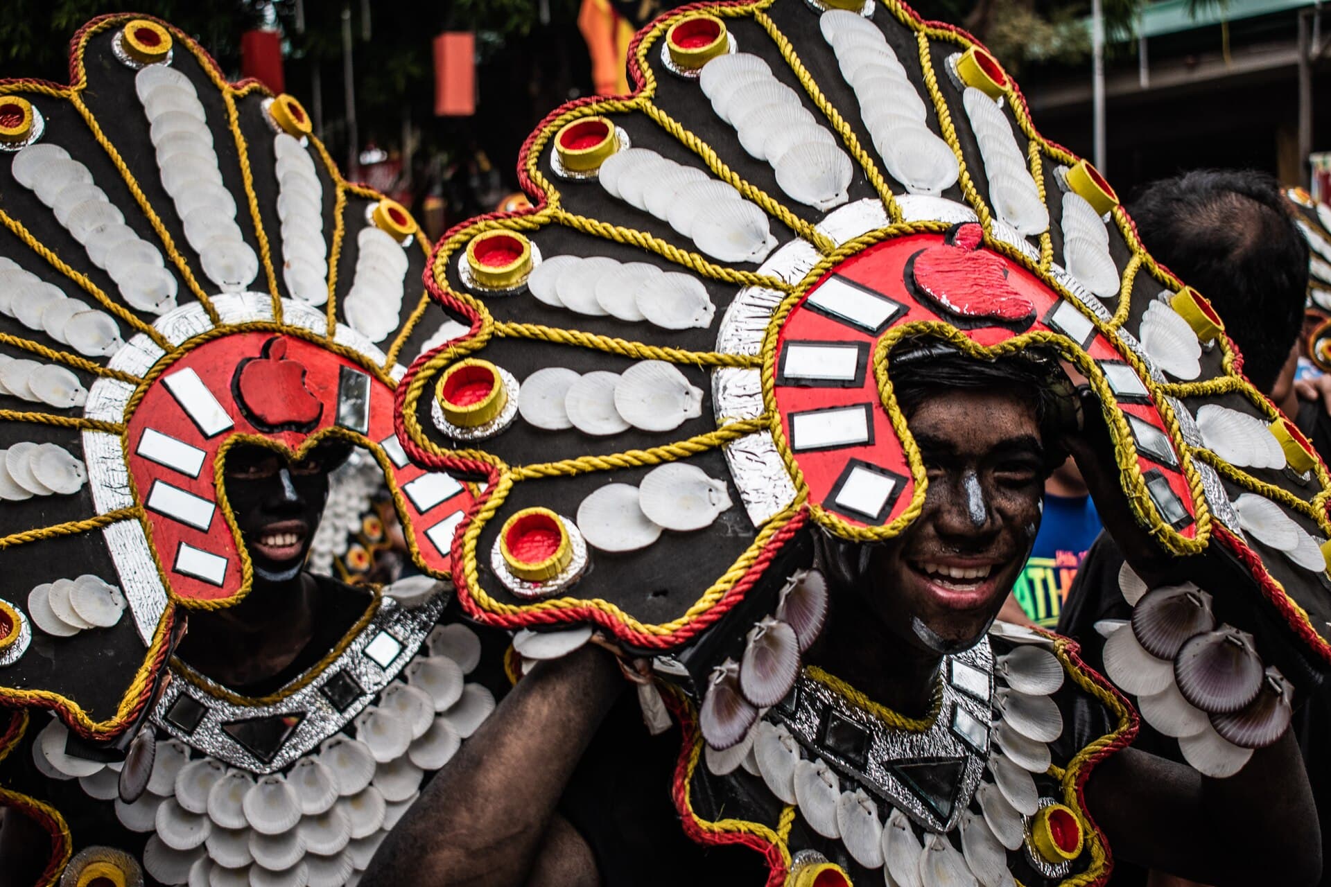 Dancers in rain ponchos and umbrellas on a wet Kalibo street during the festival