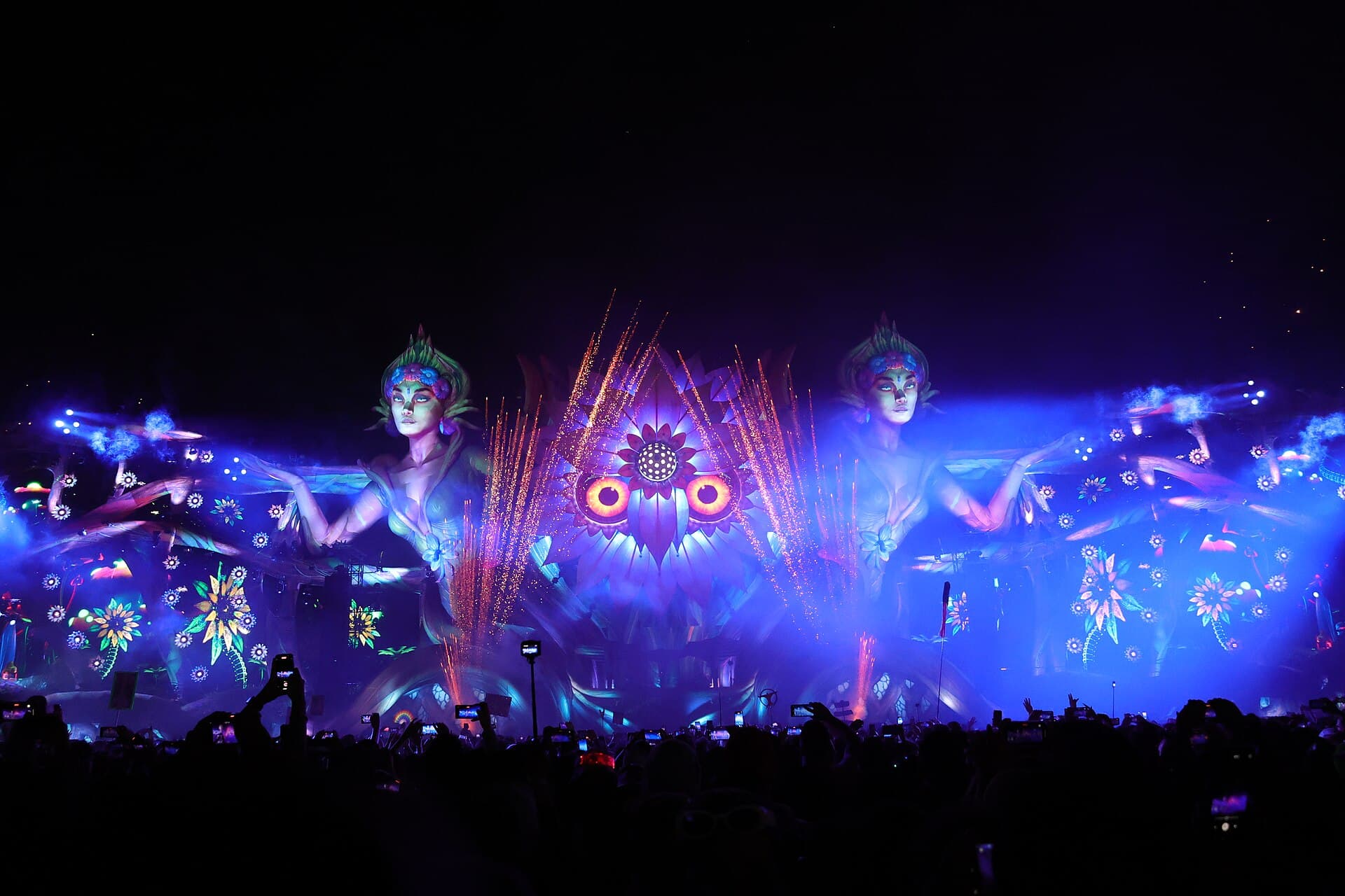 A group of friends with totems and LED outfits in the crowd at EDC Mexico