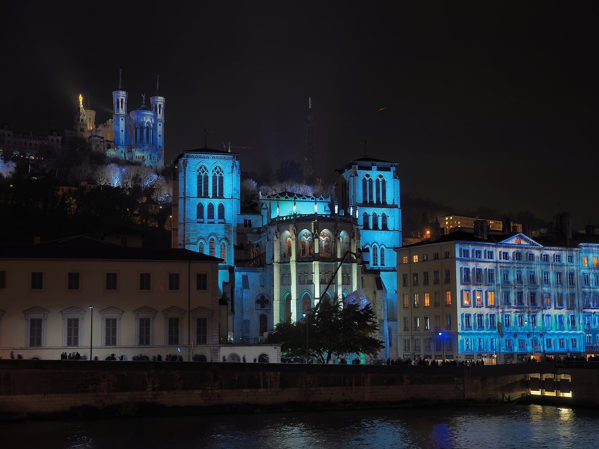 Wide shot of the Basilica of Fourvière lit up above Vieux-Lyon at night during the Fête des Lumières
