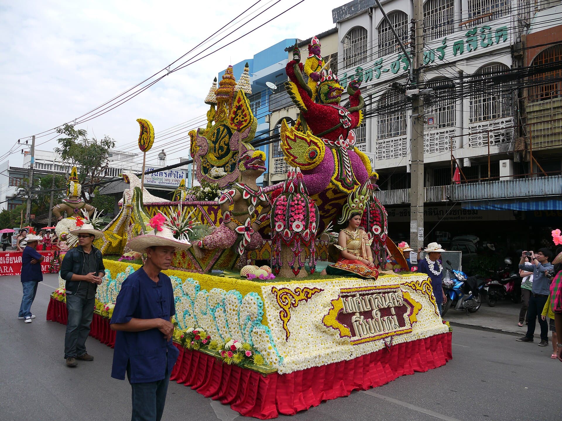 Miss Flower contestants in Lanna dress riding on a float in the parade