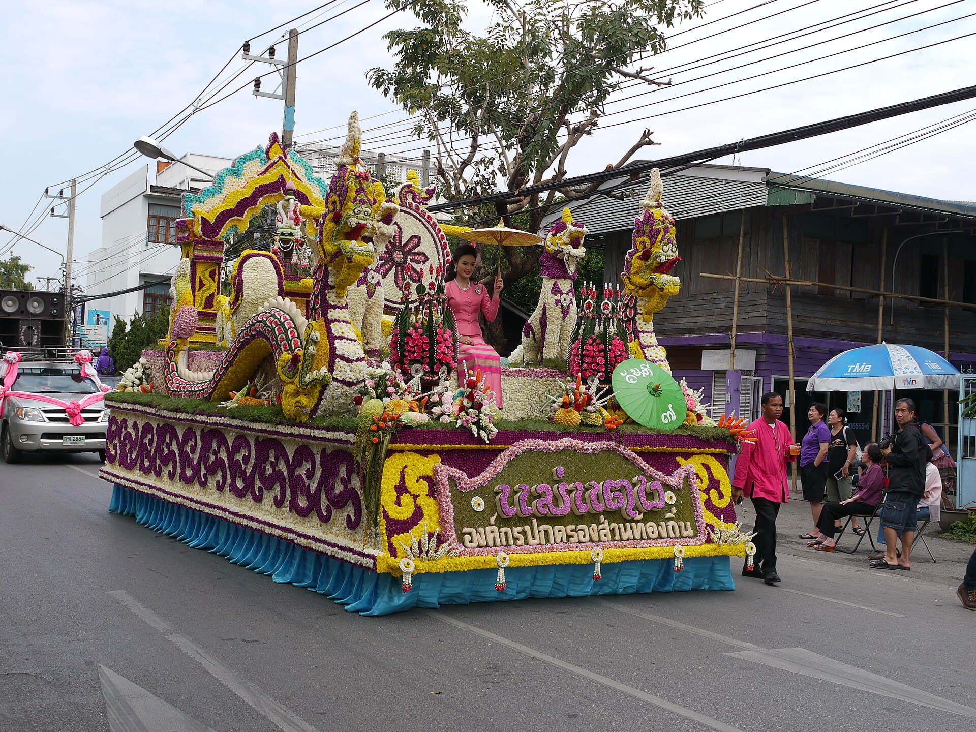 Flower-covered parade floats rolling along Thapae Road in Chiang Mai on a sunny February morning