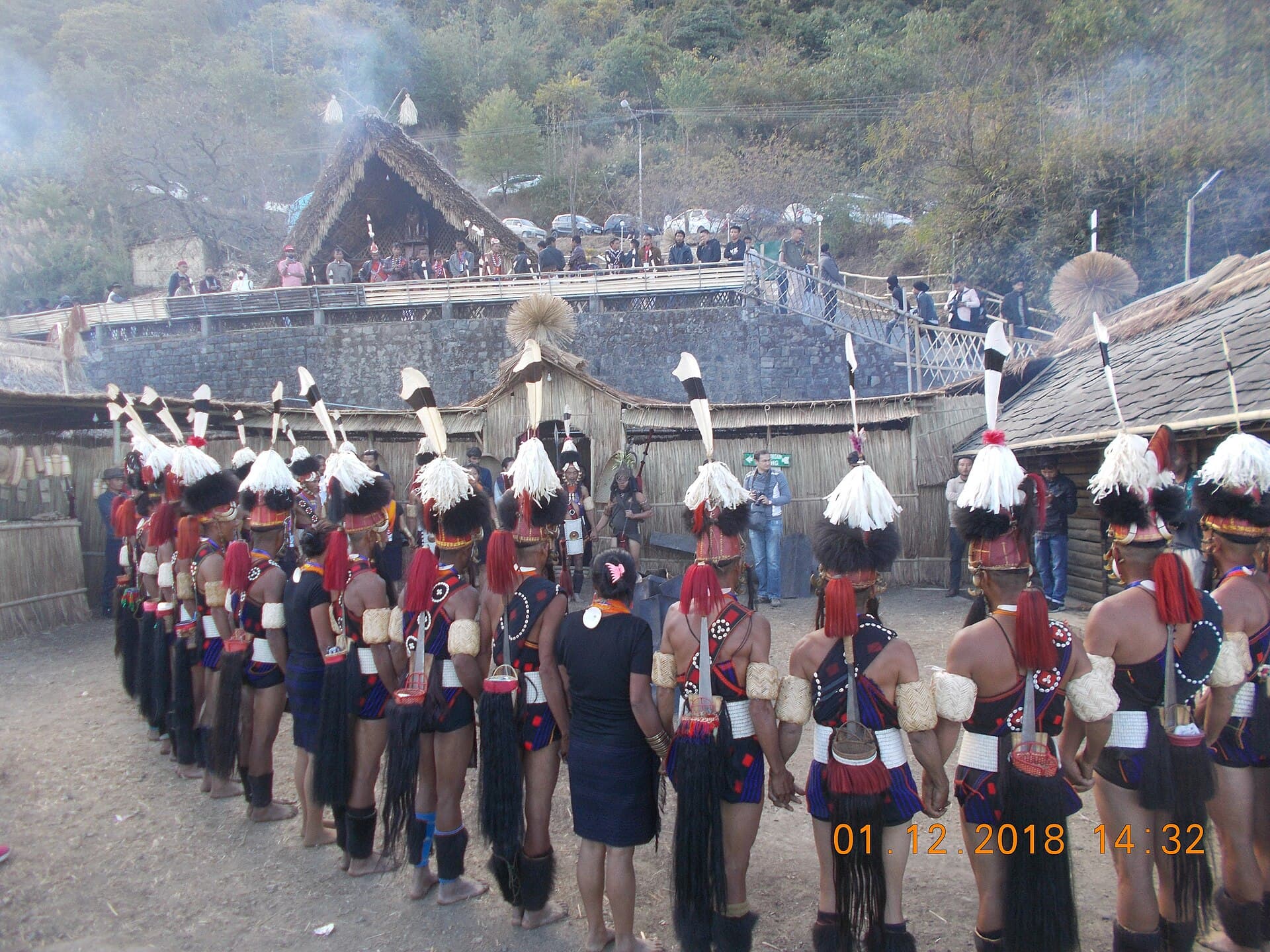 Wide shot of tribal dancers in the main arena at Kisama Heritage Village during the festival