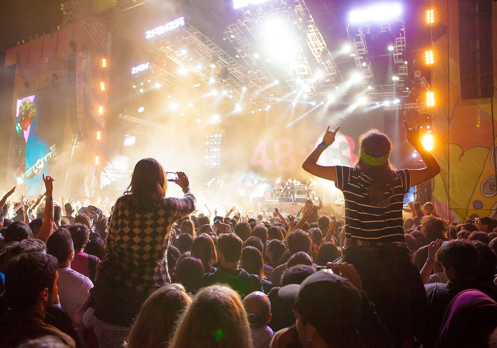 Festival-goers wearing wristbands entering a gate on Avenida Márquez at the Hipódromo de San Isidro