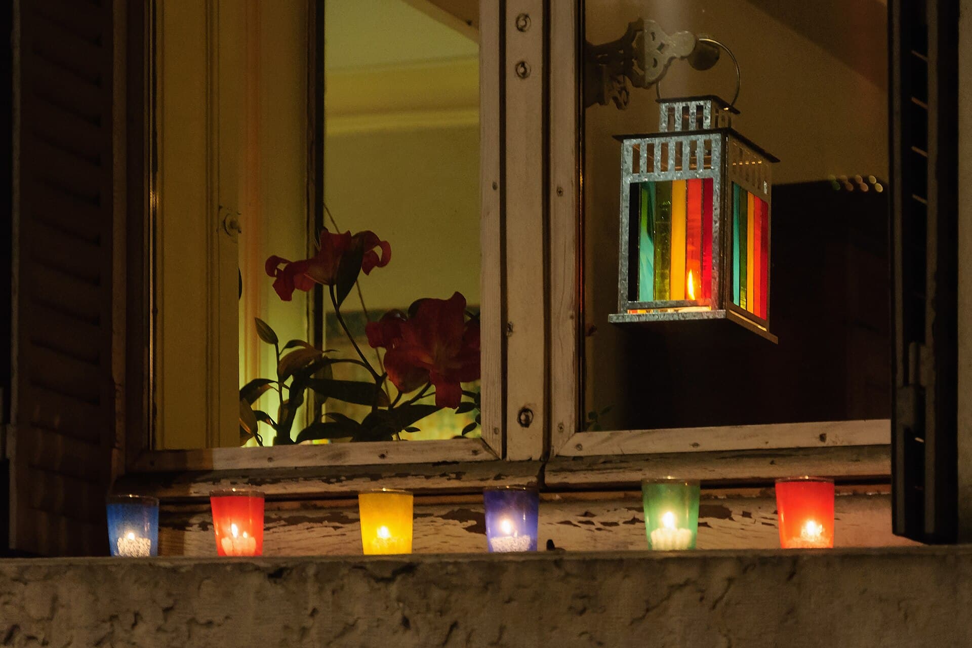 Lumignon candles in coloured glass on a Lyon windowsill on 8 December