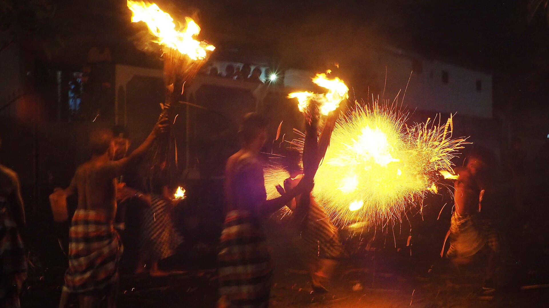 Ogoh-Ogoh demon effigy carried on a bamboo platform through a Bali street at dusk