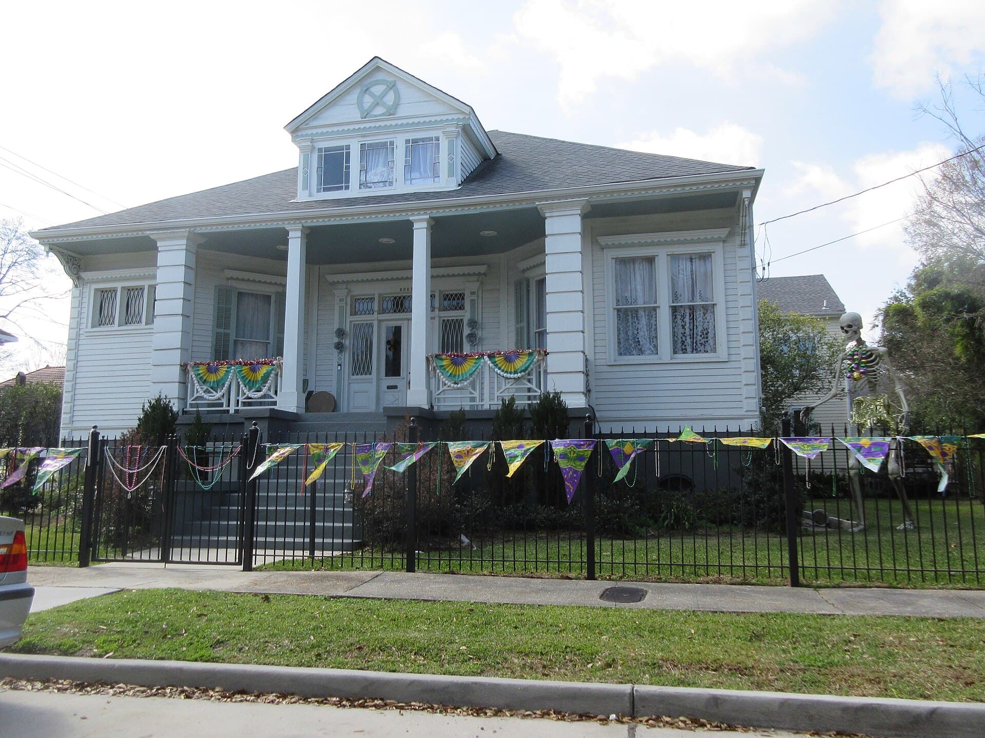 Historic houses with purple, green and gold flags along St. Charles Avenue in the Garden District of New Orleans