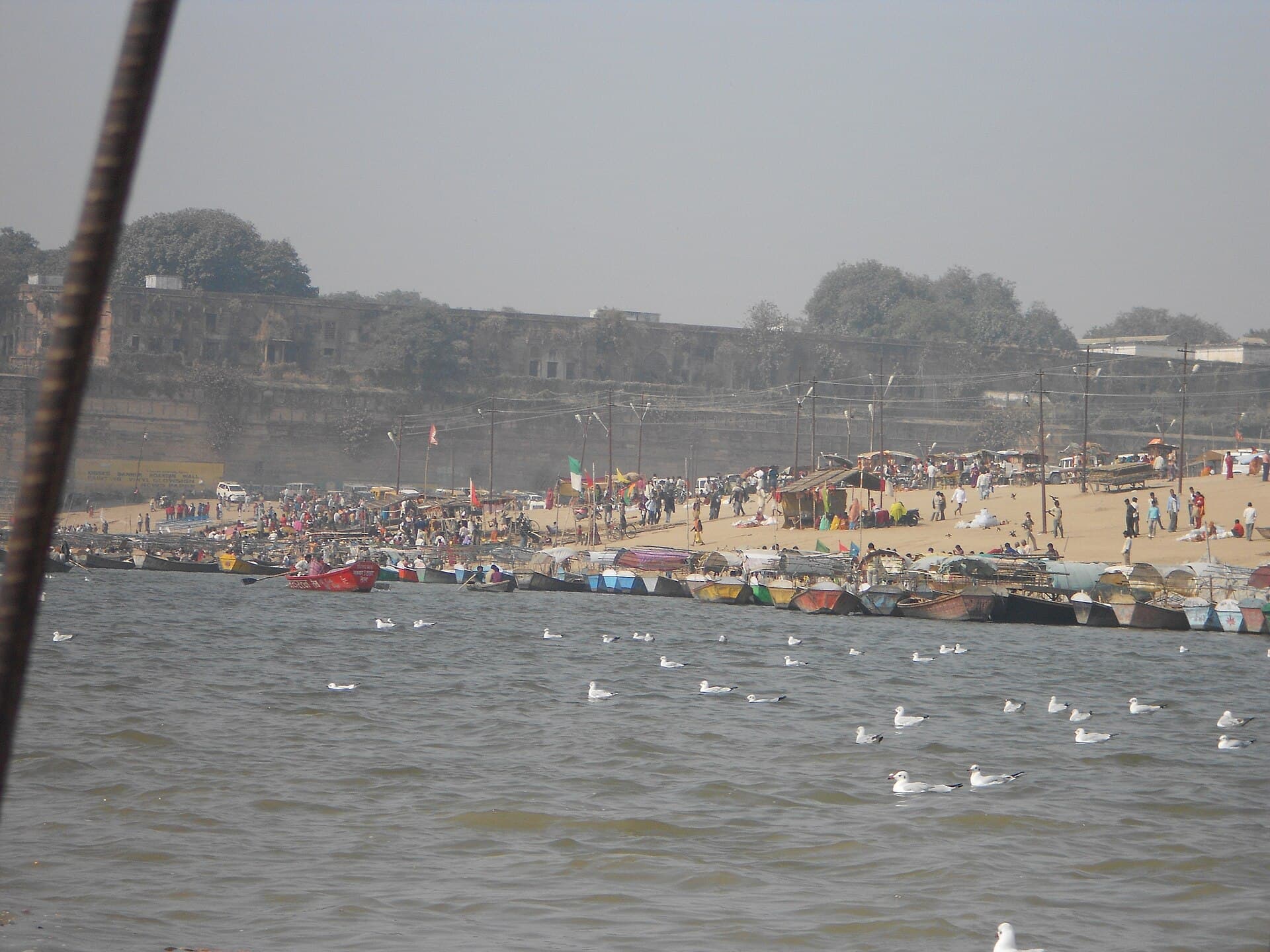 Pilgrims bathing at the Sangam on Mauni Amavasya with the Allahabad Fort in the background