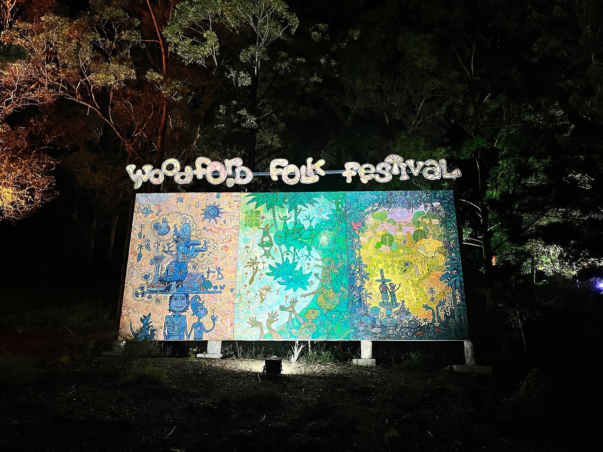 A folk band performing on a Woodfordia stage in the evening