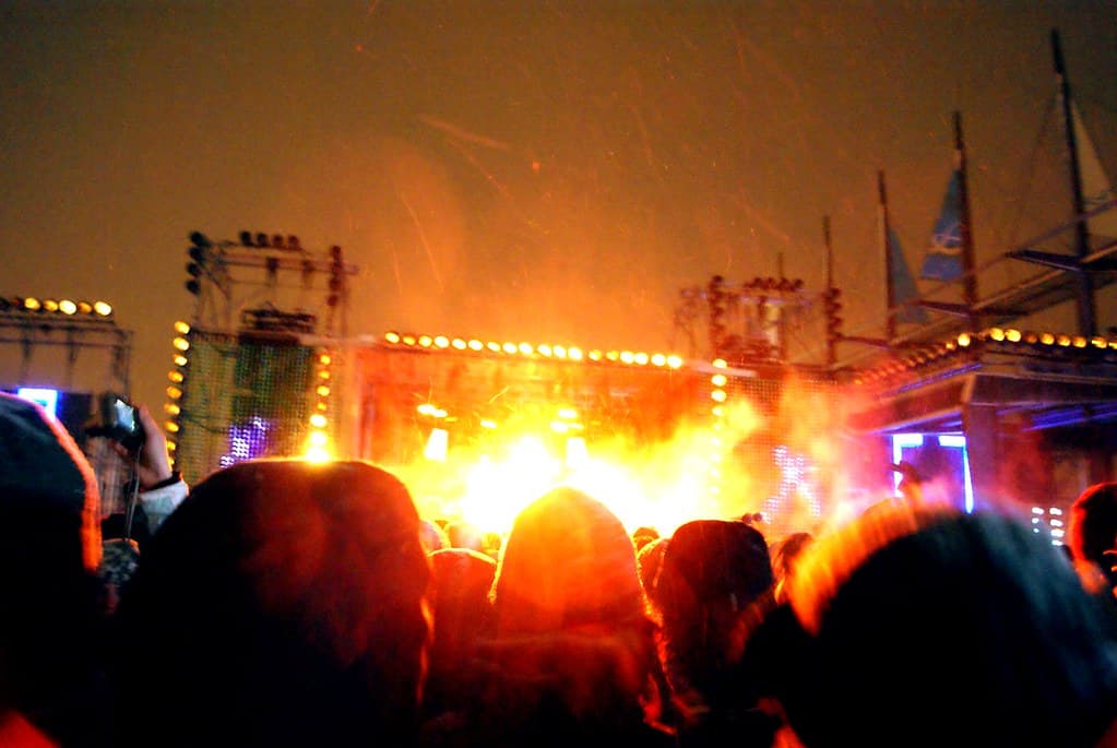 Festival-goers in parkas queuing at the Igloofest entrance gate in Old Montreal, phones out for ticket scanning