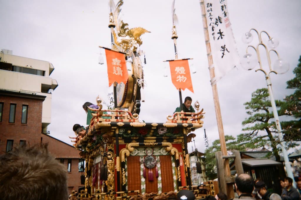 A wide view of festival floats parked along an old town street of Takayama under a clear sky
