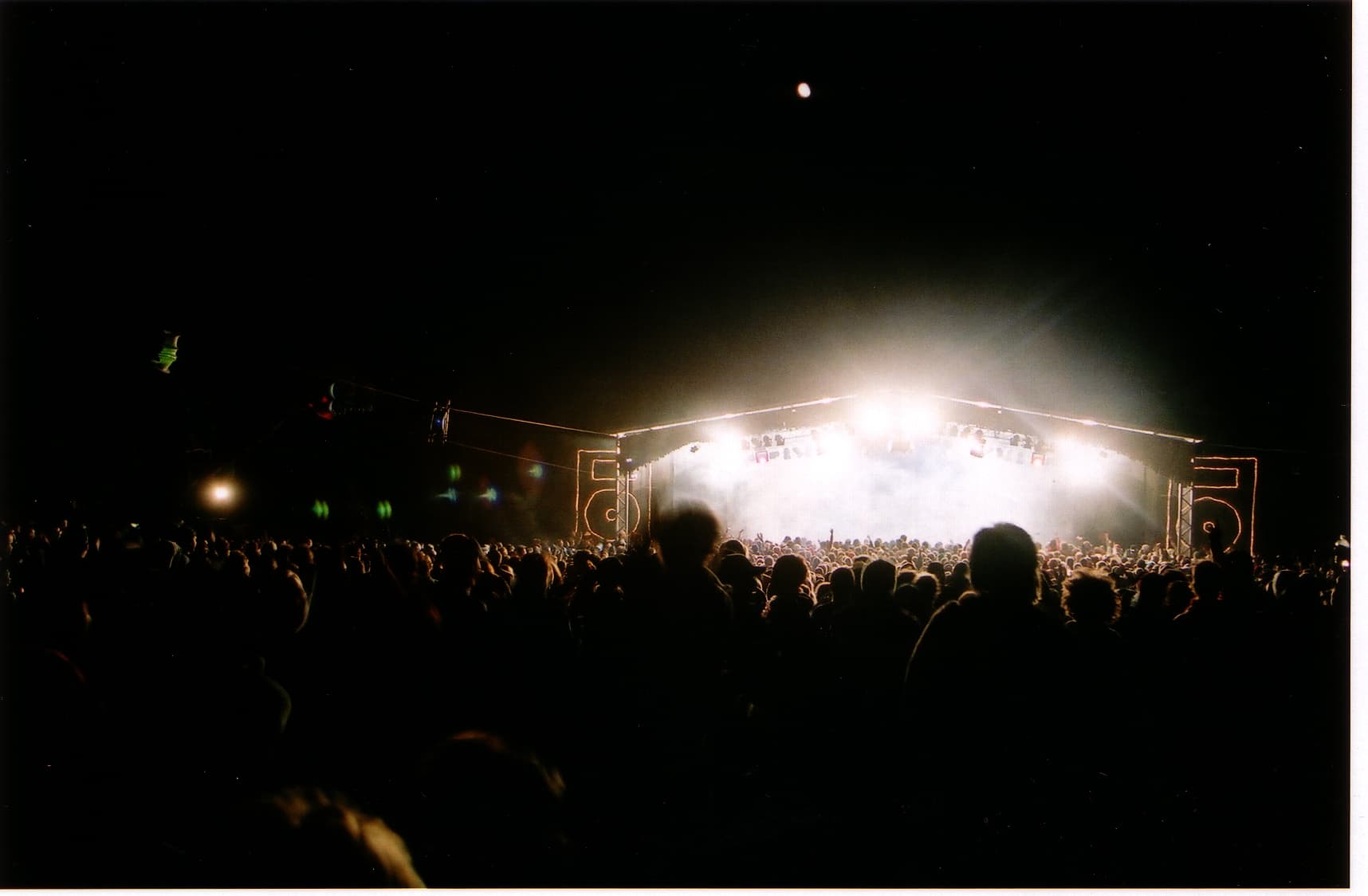The Meredith Supernatural Amphitheatre packed with festival crowds on the grassy slope facing the stage under the giant gum trees