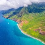 Scenic aerial view of Kauai, Hawaii with lush green mountains surrounded by the Pacific Ocean, 4-5 day itinerary for a perfect trip to Hawaii