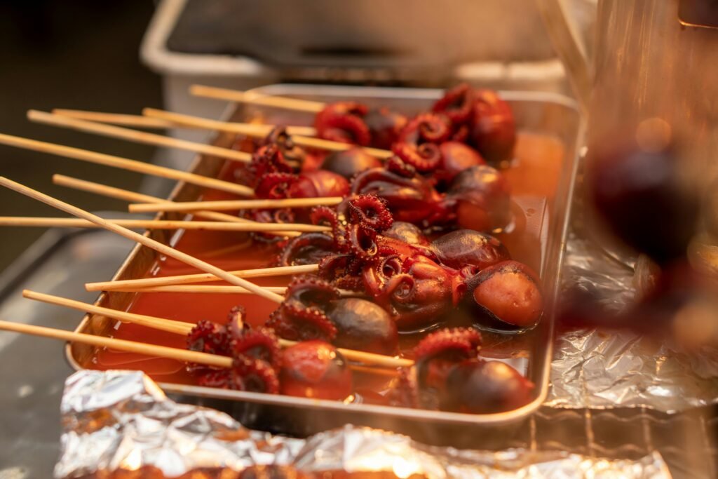 Skewered baby octopus glazed in sweet soy sauce, a popular Japanese street food snack