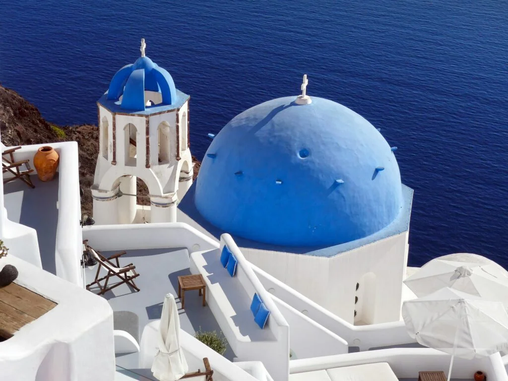 Top August travel destinations - Santorini's white buildings in peak summer season