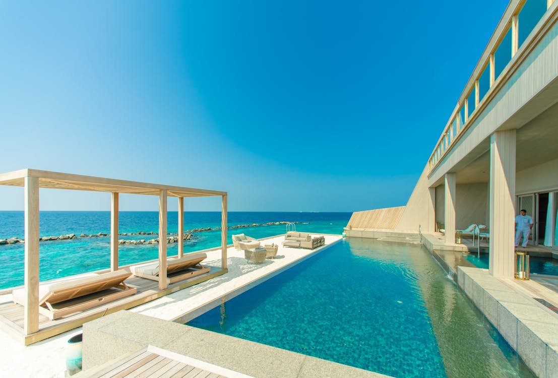 Digital nomad working remotely from a luxury resort infinity pool with ocean views
