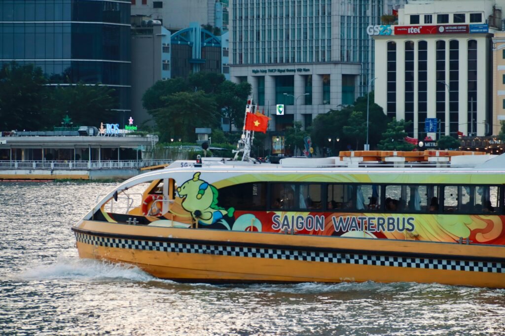 Saigon Waterbus cruising along the Saigon River in Ho Chi Minh City, offering scenic views of the urban skyline and riverside life