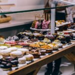 Colorful display of gourmet donuts and artisanal sweets at a dessert shop in Spain, showcasing a variety of toppings and creative flavors